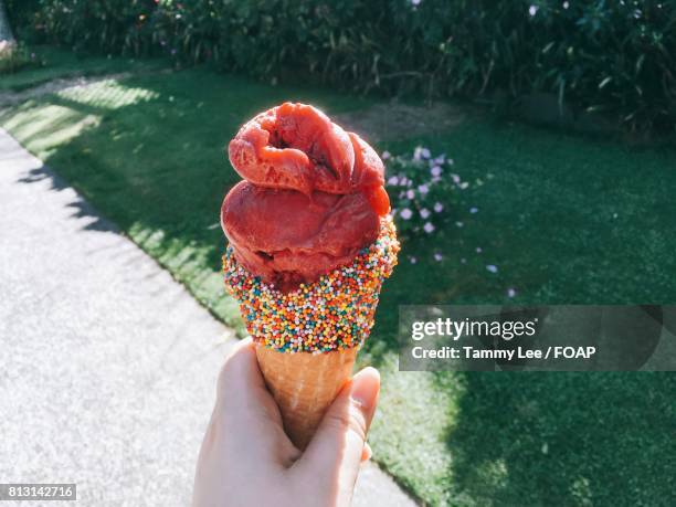 hand holding ice cream cone - raspberry sorbet stock pictures, royalty-free photos & images