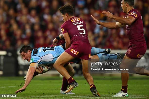 Joshua Jackson of the Blues is tackled during game three of the State Of Origin series between the Queensland Maroons and the New South Wales Blues...