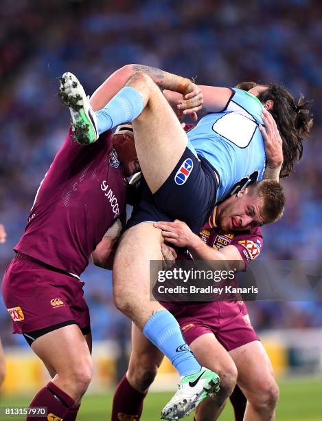 Aaron Woods of the Blues is picked up by the defence during game three of the State Of Origin series between the Queensland Maroons and the New South...