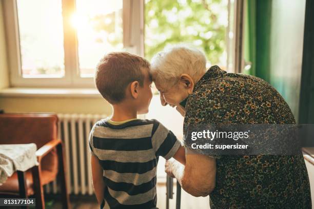 enkel besucht seine oma im kindergarten - grandmother stock-fotos und bilder