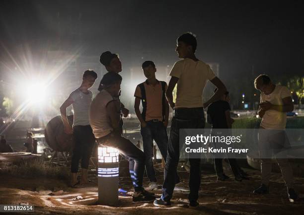 Ethnic Uyghur teenagers talk as they gather early on July 1, 2017 in the old town of Kashgar, in the far western Xinjiang province, China. Kashgar...