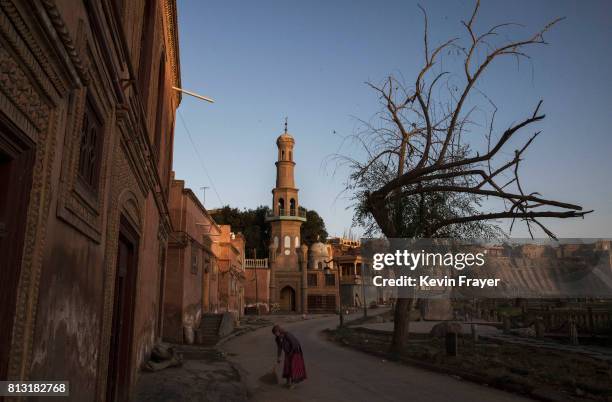 Ethnic Uyghur woman sweeps outside her house on July 1, 2017 in the old town of Kashgar, in the far western Xinjiang province, China. Kashgar has...