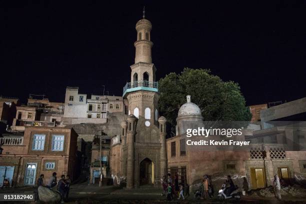 Ethnic Uyghurs walk by a closed mosque on July 1, 2017 in the old town of Kashgar, in the far western Xinjiang province, China. Kashgar has long been...