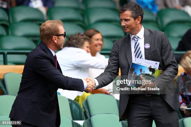 Sir Chris Hoy and Richard Krajicek shake hands in the centre court royal box on day nine of the Wimbledon Lawn Tennis Championships at the All...