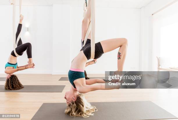 donna che si piega all'indietro durante gli esercizi di yoga aereo - piegarsi allindietro foto e immagini stock