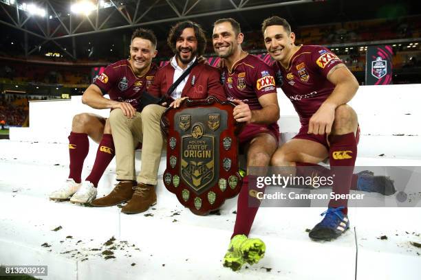 Cooper Cronk, Johnathan Thurston, Cameron Smith and Billy Slater of the Maroons pose with the State of Origin Trophy and celebrate winning the series...