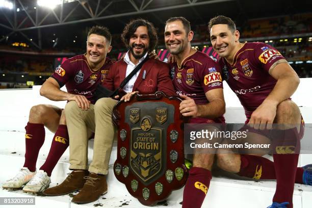 Cooper Cronk, Johnathan Thurston, Cameron Smith and Billy Slater of the Maroons pose with the State of Origin Trophy and celebrate winning the series...