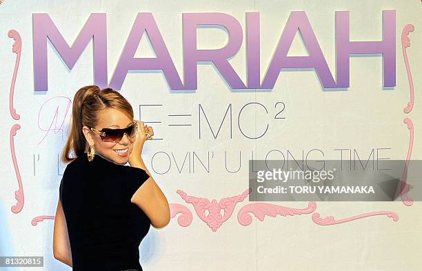 Pop star Mariah Carey signs her autograph on a board during a fan event to promote her new album "E=MC2" in Tokyo on June 1, 2008. Carey is here to...