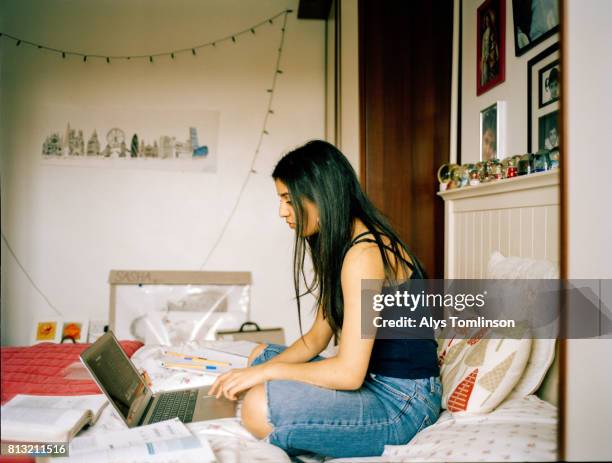 profile shot of teenage girl in her bedroom, working on laptop - ot ストックフォトと画像