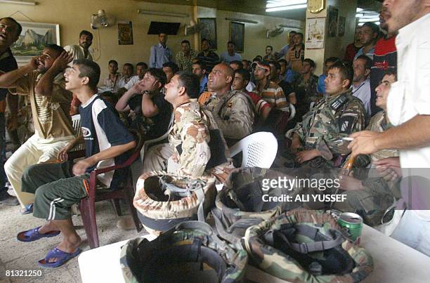 Iraqi soldiers and civilians watch the World Cup qualifying match between Iraq and Australia at a coffee shop in Baghdad on June 1, 2008. Australia's...