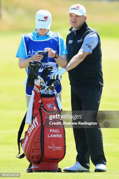 Peter Lawrie of Ireland speaks to his son and caddie Michael Lawrie during a Pro-Am prior to the AAM Scottish Open at Dundonald Links Golf Course on...