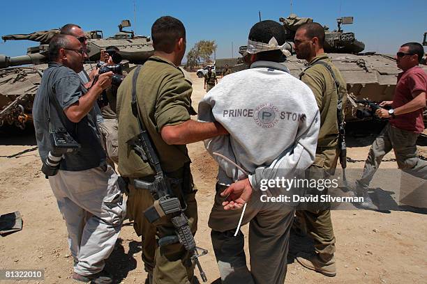 Blindfolded and bound Palestinian man detained by Israeli troops in an overnight operation in the Gaza Strip is escorted by his captors past an army...