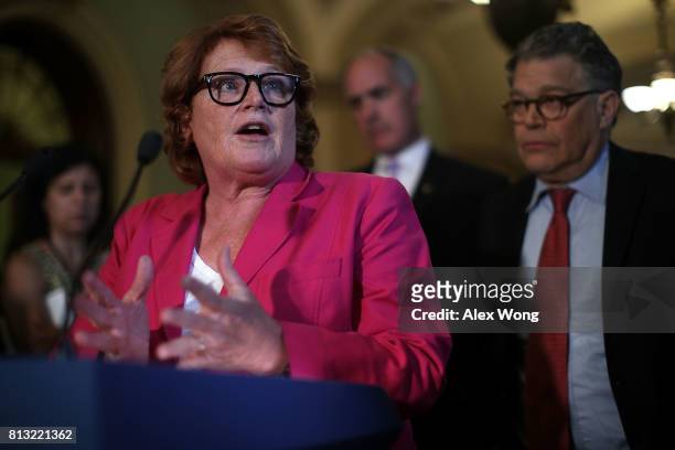 Sen. Heidi Heitkamp speaks as Sen. Al Franken listens during a news briefing after the weekly Senate Democratic Policy Luncheon July 11, 2017 at the...
