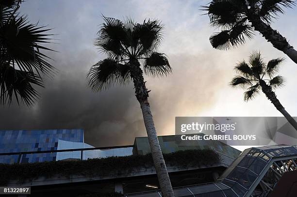 Helicopter flies over burning structures at Universal Studios, in Universal City, California, on June 01, 2008. More than 100 firefighters were...