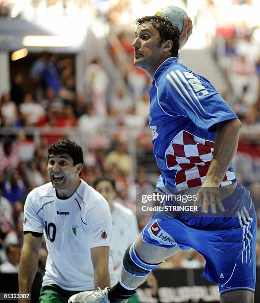 Igor Vori of Croatia tries to shoot as Saci Boultif of Algeria watches during the Handball Olympic qualification match between Algeria and Croatia in...