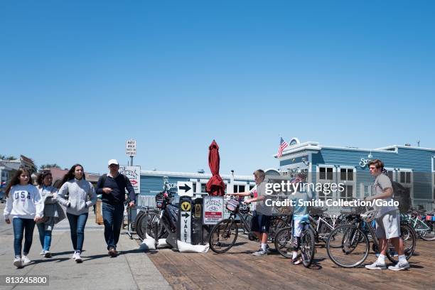 Large group of tourists stands with bicycles outside the Trident restaurant on Bridgeway Road in the San Francisco Bay Area town of Sausalito,...