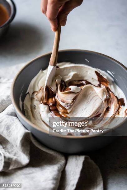 stiring a pie filling in a bowl, mixing cream, chocolate and toffee. - mixing bowl stock pictures, royalty-free photos & images