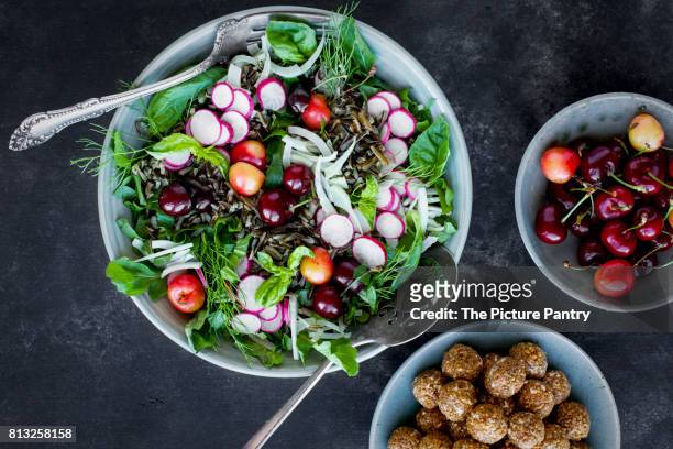 cherry wild rice salad with hibiscus vinaigrette served with white wine.  photographed on a black/gray background. - radish vinaigrette stock pictures, royalty-free photos & images