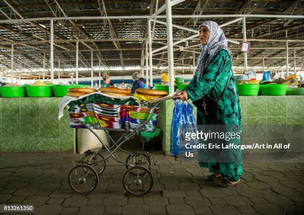 Old tajik woman selling some bread in a pram in a covered market, Gorno-Badakhshan autonomous region, Khorog, Tajikistan on August 19, 2016 in...