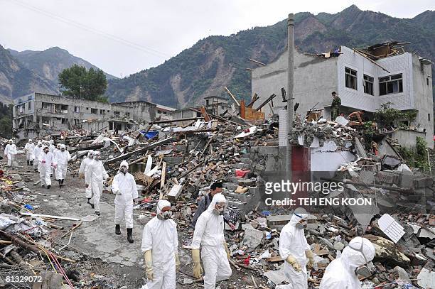 Chinese soldiers dressed in protective suits patrol through collapsed buildings at Yingxiu town of the Wenchuan county, in China's southwestern...