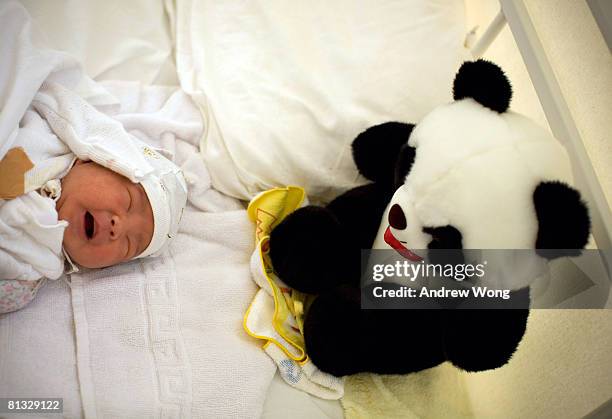 Baby boy Fang Zhongde who was born two days ago to his earthquake survivor parents cries next to a stuffed panda toy at the German Red Cross Field...