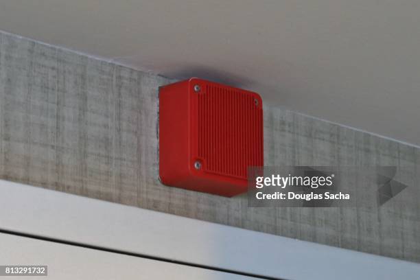 red colored siren alarm box hanging on the wall - emergency siren stock-fotos und bilder