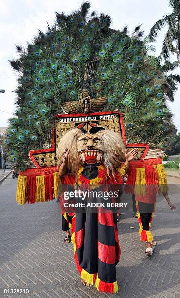 Dancers perform Reog Ponorogo on a street in Jakarta on May 31, 2008. Reog Ponorogo is particapated by several dancers wearing bright colorful...