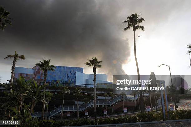 Helicopter flies over burning structures at Universal Studios, in Universal City, California, on June 01, 2008. More than 100 firefighters were...