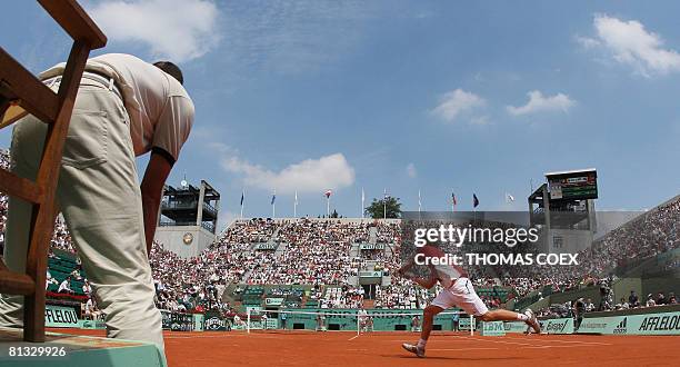 Latvian player Ernests Gulbis hits a return to French player Michael Llodra during their French tennis Open fourth round match at Roland Garros, on...