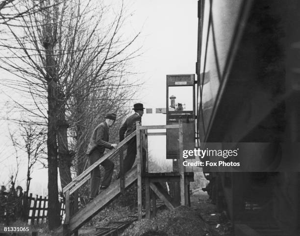 Two employees of the London and North Eastern Railway return to the temporary District Manager's Office in a railway carriage in the countryside...