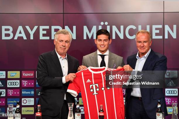 Head coach Carlo Ancelotti and Karl-Heinz Rummenigge, CEO of FC Bayern Muenchen present James Rodriguez with his new jersey during a press conference...