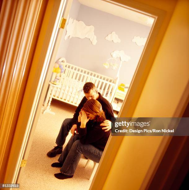 a couple in a baby room - miscarriage stock-fotos und bilder