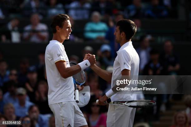 Novak Djokovic of Serbia shakes hands with Tomas Berdych of The Czech Republic as he retires injured during the Gentlemen's Singles quarter final...