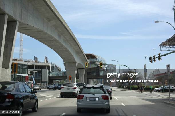 skytrain above lougheed highway, vancouver, canada, in summer - vancouver skytrain stock pictures, royalty-free photos & images