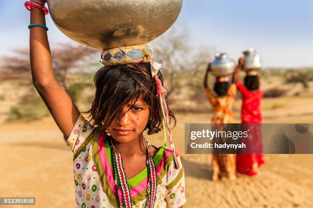 indian little girls carrying on their heads water from well - child labour stock pictures, royalty-free photos & images