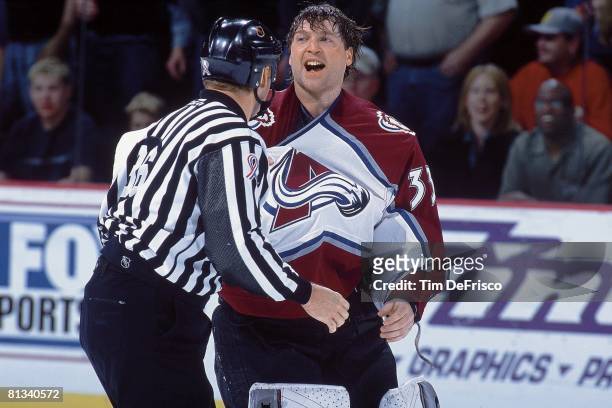 Hockey: Colorado Avalanche goalie Patrick Roy with official upset after fight during game vs Detroit Red Wings, Denver, CO 3/23/2002