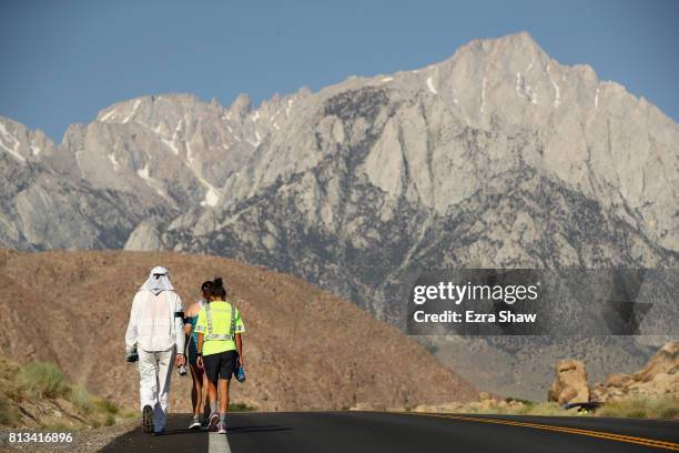 Kayla Delk and Kevin Delk walk with members of their support teams during the STYR Labs Badwater 135 on July 12, 2017 in Death Valley, California....