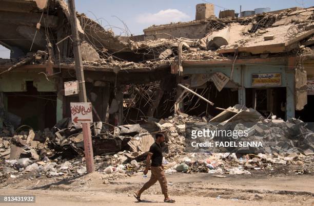 Man walks along a damaged street in west Mosul on July 12 a few days after the government's announcement of the "liberation" of the embattled city...
