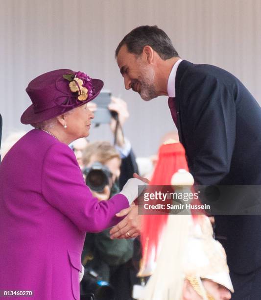 King Felipe VI of Spain kisses the hand of Queen Elizabeth II at a Ceremonial Welcome on Horse Guards Parade during a State visit by the King and...