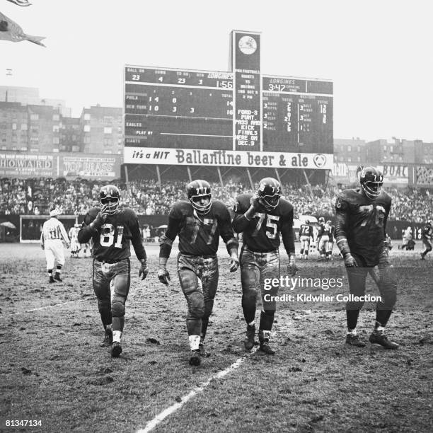 Defensive linemen Andy Robustelli, Dick Modzelewski, Jim Katcavage and Roosevelt Grier of the New York Giants, walk towards the sidline during the...