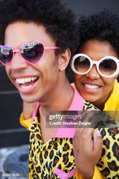 an affectionate young couple wearing sunglasses smiling and laughing - hipster couple stock pictures, royalty-free photos & images