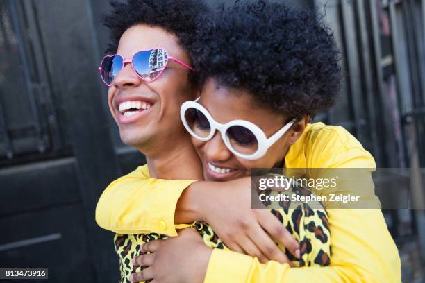 a young woman hugging her boyfriend from behind - hipster couple stock pictures, royalty-free photos & images