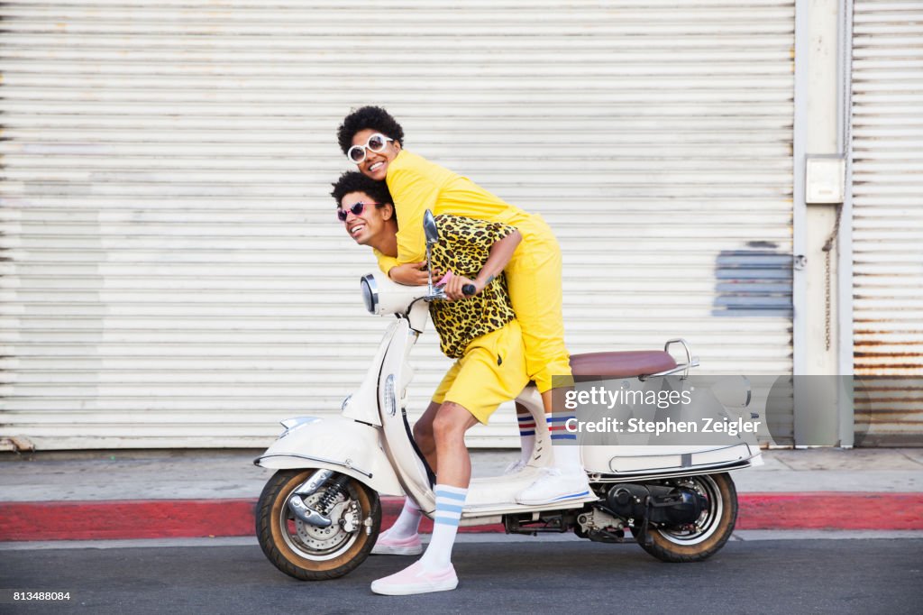 A hip young couple on a scooter