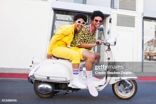 young couple riding a scooter - fashion photos et images de collection