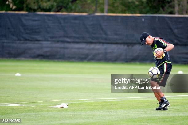 Mexico coach Juan Carlos Osorio juggles a soccer ball while setting up a skills course for players during a team practice at Prentup Field on the...