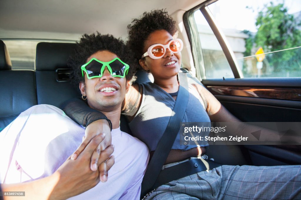 Young couple sitting in the back of a car