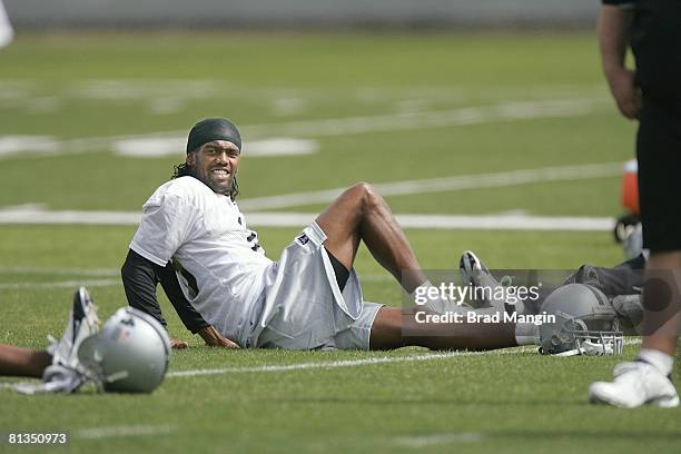 Football: Oakland Raiders Randy Moss sitting on field, stretching during mini camp workout, Oakland, CA 4/29/2005