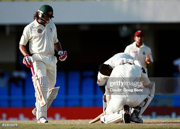 Fidel Edwards of West Indies and Andrew Symonds of Australia check on Brett Lee of Australia after he was hit on the head by a bouncer during day...