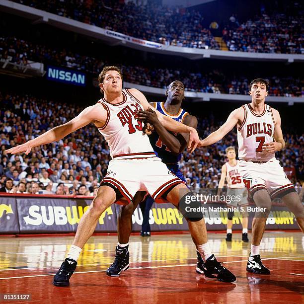 Luc Longley and Tony Kukoc of the Chicago Bulls boxes out against Anthony Mason of the New York Knicks in Game Three of the Eastern Conference...