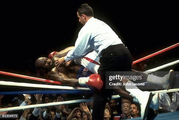 Boxing: WBC/WBA/IBF/IBO Heavyweight Title, Lennox Lewis in action, pushing Evander Holyfield out of ring at Thomas & Mack Center, View of referee...